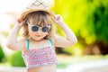 Close-up portrait of adorable little girl at the tropical resort, palm trees at the background, sunny summer day Royalty Free Stock Photo