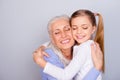 Close up portrait of adorable small lovely sweet charming beautiful girl hugging her careful attentive with white hair granny Royalty Free Stock Photo
