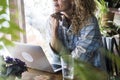 Close up portrait of adult woman working and using laptop computer sitting at the table at home or shop - concept of modern Royalty Free Stock Photo