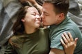 Close-up portrait of affectionate kissing couple in casual clothes, top view