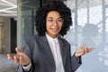 Close-up portrait of an African-American businesswoman sitting in a suit in the office at a desk and talking to the Royalty Free Stock Photo