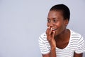 Close up african american woman smiling with her hand covering mouth on gray background Royalty Free Stock Photo