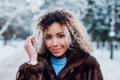 Close-up portrait of afro american girl wearing in fur coat and walking in winter park Royalty Free Stock Photo