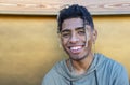 Close up portrait of alternative black man hanging out chilling and smiling standing isolated against  modern wood background wall Royalty Free Stock Photo