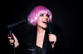Close-up portrait of amazing female model in pink wig with comb and hair dryer. Studio photo funny humoured girl in wigs Royalty Free Stock Photo