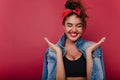 Close-up portrait of amazing smiling girl posing on claret background. Photo of brunette european lady in denim jacket