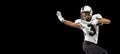 Close-up portrait of American football player playing in sports equipment, helmet and gloves isolated on dark studio Royalty Free Stock Photo