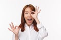 Close-up portrait amused and excited asian woman in white shirt, look amazed glancing through okay gesture with