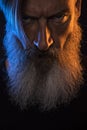 Close up portrait of an angry bearded man with orange and blue light