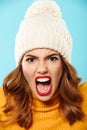 Close up portrait of an angry furious girl in winter hat