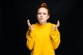 Close-up portrait of angry mad young woman in yellow sweater screaming on isolated black background Royalty Free Stock Photo