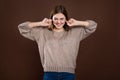 Portrait of angry stressed out woman plugging ears with fingers, irritated with loud annoying noise