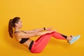 Close up portrait of athletic woman shaking press, slim beautiful female posing over yellow background, sporty girl working out Royalty Free Stock Photo