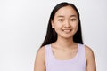 Close up portrait of attractive aisan woman with white smile, looking happy, standing in tank top over white background