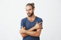 Close up portrait of attractive bearded man with good-looking hairstyle crossing hands on chest, looking at camera with