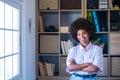 Close-up portrait of attractive dark skinned young woman with curly Afro hairstyle. African american businesswoman smiling with Royalty Free Stock Photo