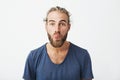 Close up portrait of attractive funny guy with stylish hairstyle and beard showing tongue and making silly expression