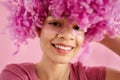 Close up of portrait of attractive happy darkskinned girl with soft pink curly wig Royalty Free Stock Photo