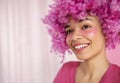 Close up of portrait of attractive happy darkskinned girl with soft pink curly wig