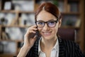 Close up portrait attractive red hair businesswoman holding cell phone talking with client Royalty Free Stock Photo