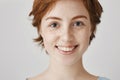 Close-up portrait of attractive redhead woman with cute freckles and clean perfect skin, smiling broadly, being in good