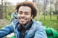 Close-up portrait of attractive unshaved dark-skinned man with afro hairstyle, smiling and expressing happiness while Royalty Free Stock Photo