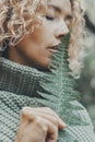 Close up portrait of attractive woman and big tropical leaf near her face. Feeling with nature and people concept lifestyle. Green Royalty Free Stock Photo