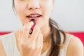 Close up portrait of attractive woman holding light pink lipstick apply to lips focus hand and lipstick,Concept beauty and charm