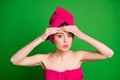 Close-up portrait of attractive worried lady wearing turban touching forehead pustule isolated on bright green color