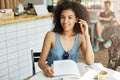 Close up portrait of attractive young black-skinned female freelancer with wavy dark hair in fashionable blue shirt Royalty Free Stock Photo