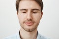 Close-up portrait of attractive young male model with bristle, standing with closed eyes and slight smile, being relaxed Royalty Free Stock Photo