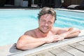 Portrait of attractive young man on edge of home swimming pool Royalty Free Stock Photo
