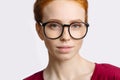 Portrait of attractive young redhead woman smiling with glasses