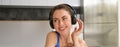 Close up portrait of attractive young smiling woman, workout, doing fitness training, listening music in headphones Royalty Free Stock Photo