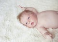 Close-up portrait of baby on white soft shawl. one month infant