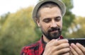 Close-up portrait of a bearded caucasian farmer in a hat who is holding a tablet. Smart organic farm Royalty Free Stock Photo