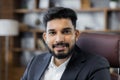 Close up portrait of bearded handsome successful middle east smiling businessman sitting at chair Royalty Free Stock Photo