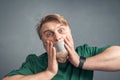 A close-up portrait of a bearded man with his mouth taped shut, holding his hands over his face in horror Royalty Free Stock Photo