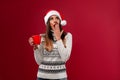 Close up portrait beautifiul caucasian woman in red Santa hat on red studio background. Christmas and New Year holiday concept Royalty Free Stock Photo