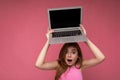 Close-up portrait of Beautiful amazed young woman saying wow with open mouth holding netbook computer looking at camera Royalty Free Stock Photo