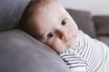 Close up portrait of beautiful baby boy lying on the sofa and looking at the camera. Family concept Royalty Free Stock Photo