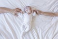 close up portrait of a beautiful baby on white background at home. mother and father hands holding baby hands Royalty Free Stock Photo