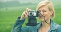 Close up portrait of beautiful blonde female photojournalist traveling and taking picture outdoors