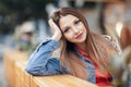 Close up portrait of a beautiful blonde girl Hand Lean Face sitting outdoor in cozy cafe in town. Pretty young model looking at ca Royalty Free Stock Photo