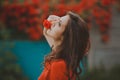 Close-up portrait of beautiful brunette woman with red rose in her lips. Toned image Royalty Free Stock Photo