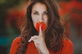 Close-up portrait of beautiful brunette woman with red rose in her lips. Toned image Royalty Free Stock Photo