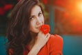 Close-up portrait of beautiful brunette woman with red rose in her lips. Toned image Royalty Free Stock Photo