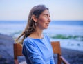 Close up portrait of beautiful Caucasian woman. Smiling woman wearing blue dress and sitting in the beach bar. Travel lifestyle. Royalty Free Stock Photo