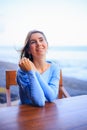 Close up portrait of beautiful Caucasian woman. Smiling woman wearing blue dress and sitting in the beach bar. Travel lifestyle. Royalty Free Stock Photo