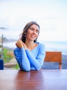 Close up portrait of beautiful Caucasian woman. Smiling woman wearing blue dress and sitting in the beach bar. Travel lifestyle. Royalty Free Stock Photo